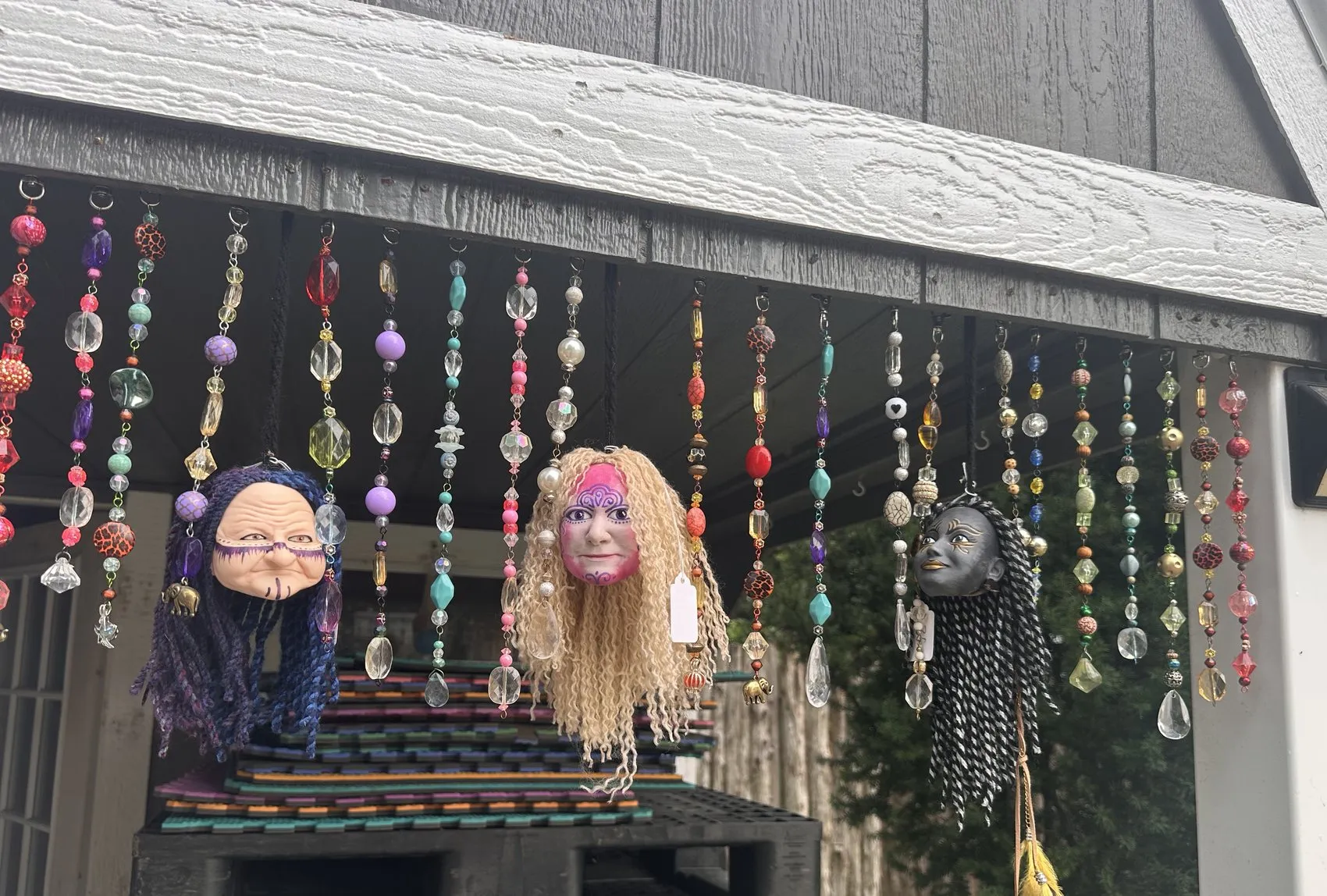 Strings of glass beads and charm ornaments hanging across the booth front